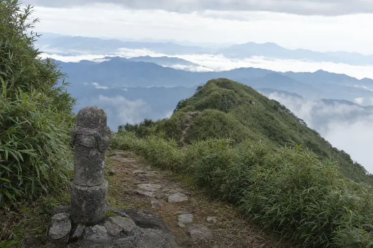 A ridge trail through bamboo above layered valleys at Moganshan